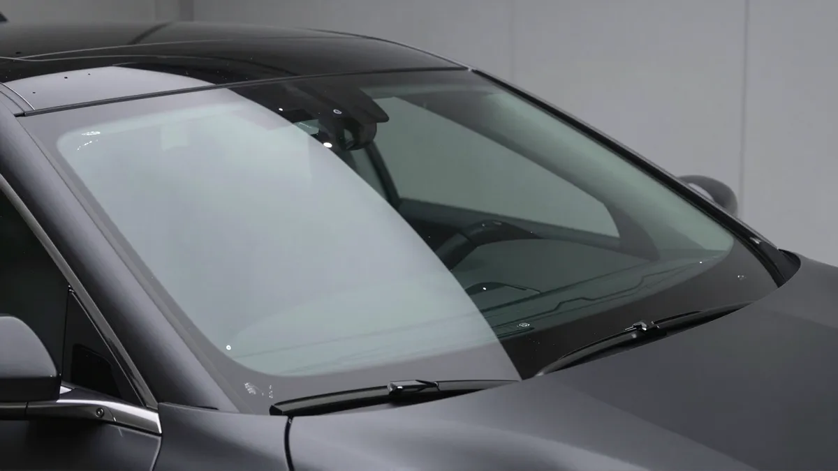 Eine makellose neue Windschutzscheibe in einem Luxusauto, perfekt in das dunkle Armaturenbrett eingepasst.