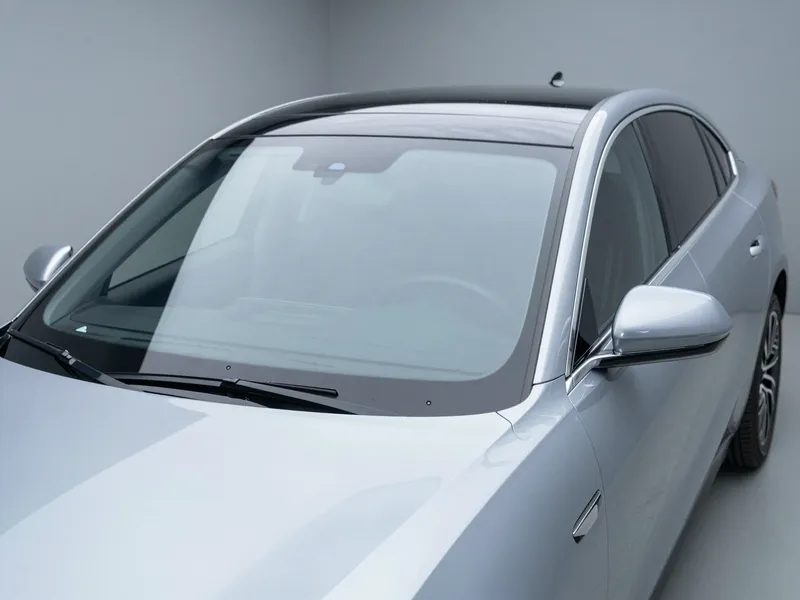 Ein moderner silberner SUV mit einer makellos eingebauten Windschutzscheibe in einer sauberen Autowerkstatt.